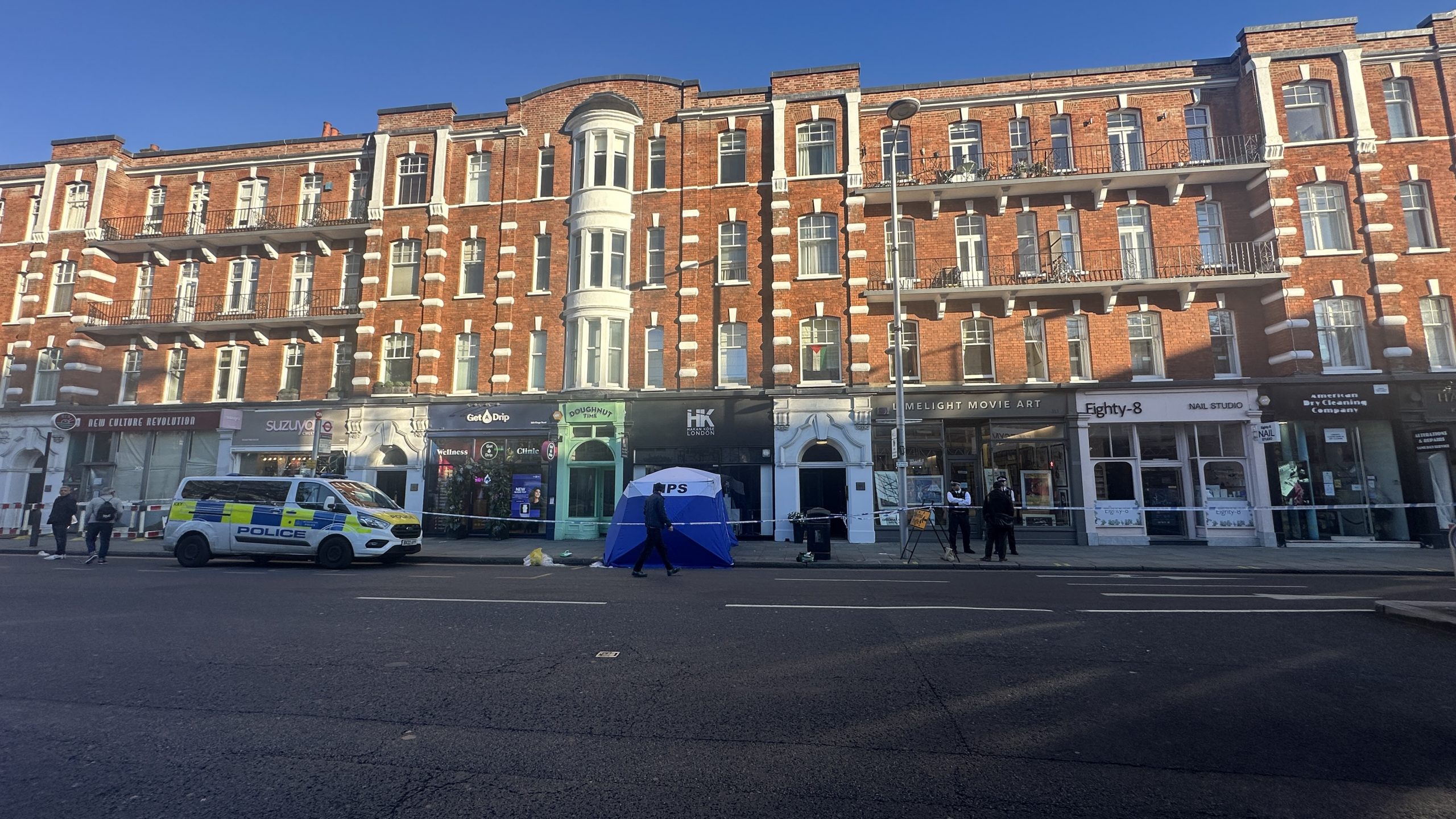A police forensics canopy is in situ to hide the victim. It is believed that he fell from a second floor flat